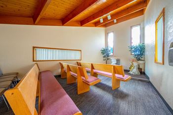 a small chapel with wooden benches and a whiteboard on the wall